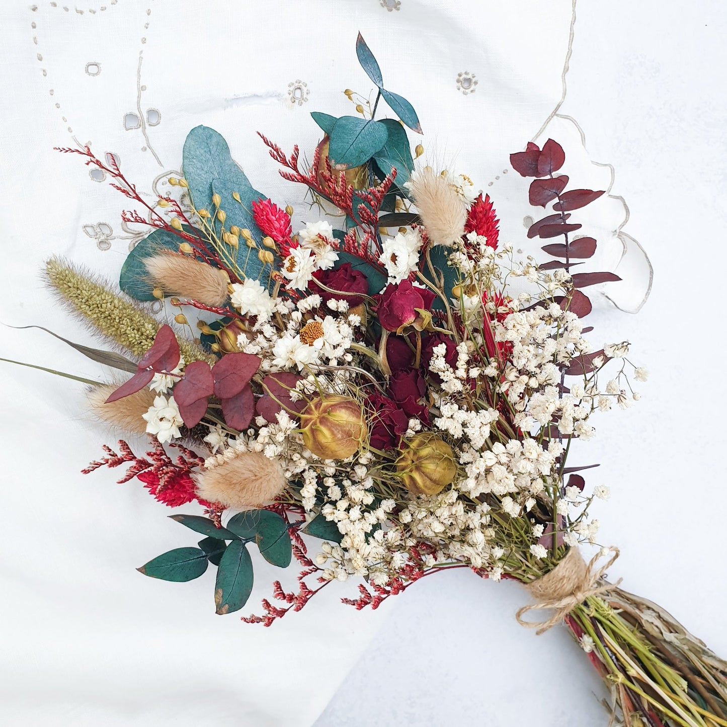"Winter Woodlands" Preserved Eucalyptus & Dried Roses Small Bouquet - Lytton Rose Botanical. A beautifully arranged bouquet of dried flowers, showcasing a mix of white gypsophila, red roses, and green and burgundy eucalyptus leaves.